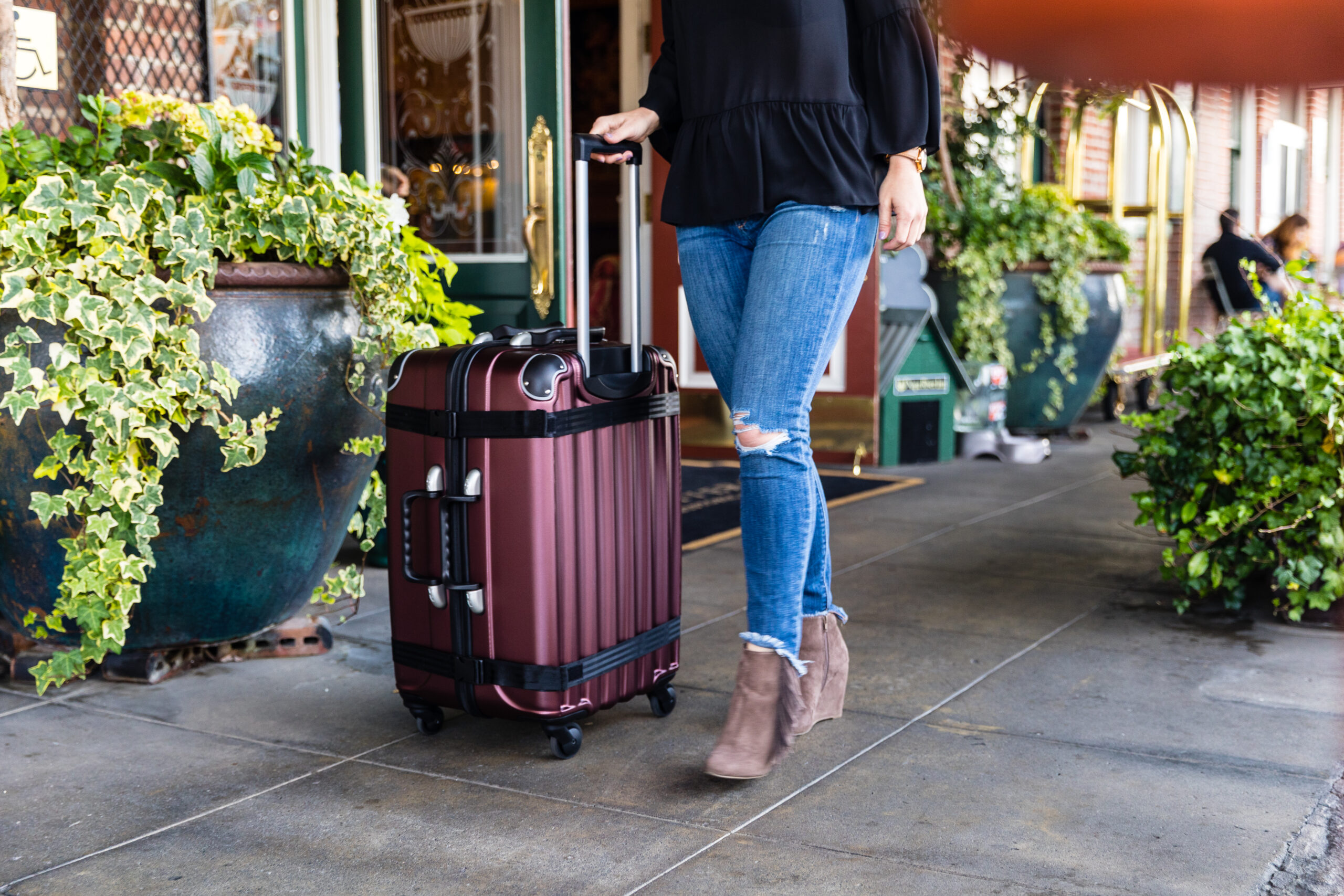 Woman with wine suitcase on sidewalk